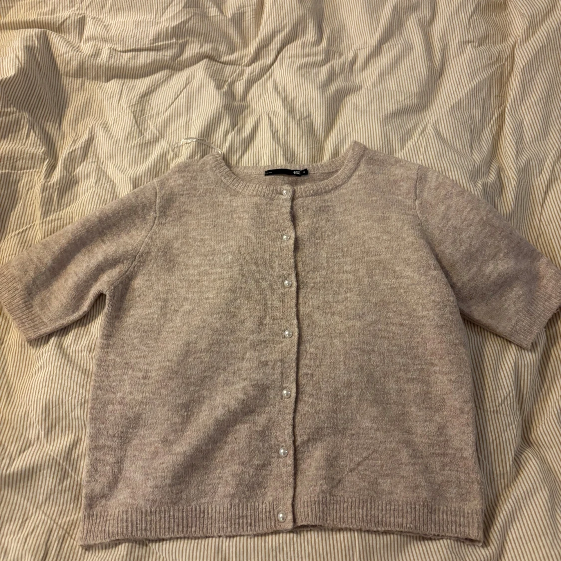 Beige kofta med pärlknappar från 157