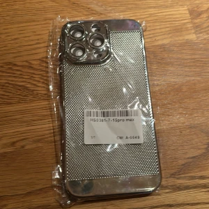 iPhone 15 Pro Max Skal Silver - Stilrent silverskal till iPhone 15 Pro Max med metallisk finish och texturerad yta. Nytt, fortfarande i plastförpackning. Ger extra skydd och elegant utseende till din telefon. Passar perfekt runt kameran och knapparna.