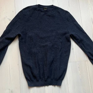 Mörkblå tröja från Massimo Dutti - Mörkblå långärmad tröja från Massimo Dutti i extrafin bomull. Enkel och stilren design med rund halsringning och ribbade muddar. Perfekt för lager-på-lager och passar till många olika outfits.