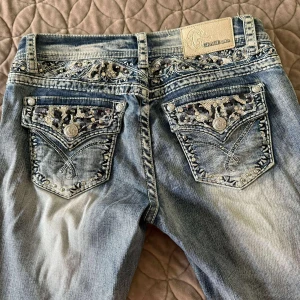 Grace in LA ljusblå jeans med paljetter - Snygga ljusblå vintage style bootcut jeans från Grace in LA.  och detaljerade bakfickor med paljetter och broderier. Vill bara påpeka att bensluten är omsydda. Storlek 28 står det men de passar 27 också. Skriv om du har några funderingar! 💞