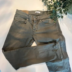 Gråa byxor från Dondup - Dondup chinos med en urtvättad grå färg med klassisk femficksdesign och raka. Byxorna har tecken på användning men är i bra skick. Skulle uppskatta att de är en M modell med slim fit