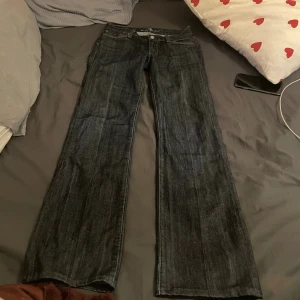 lågmidjade jeans  - Snygga mörkblå jeans med klassisk bootcut/straight-passform. Jeansen har låg midja och raka ben som blir vidare nertill. Tillverkade i slitstarkt denimtyg med fem fickor och knappgylf. Perfekta för en avslappnad och trendig look. Nypris 3000