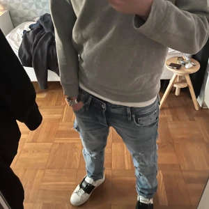 Grå crewneck från Polo Ralph Lauren - Säljer en stilren grå crewneck från Polo Ralph Lauren med klassisk broderad logga på bröstet. Tröjan har rund halsringning, långa ärmar och är tillverkad i mjuk bomull. Givetvis äkta! Storlek XL junior sitter som S.