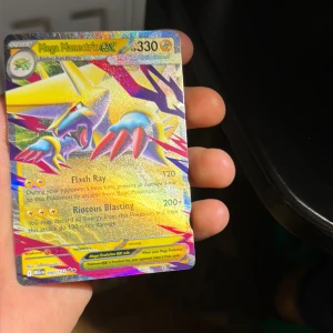 Mega Manectric GX - Mega Manectric GX är ett glittrande och färgstarkt Pokémon-samlarkort med kraftfulla attacker som Flash Ray och Riotous Blasting. Perfekt för dig som älskar Pokémon och vill boosta din samling med ett unikt och coolt kort!