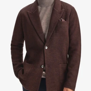 Ny brun kavaj John Henric Merino  XS - Grym stickad kavaj från John Henric  i mörkbrunt merino.  Slim modell med två knappar framtill. Funkar lika bra med jeans o T-shirt, som till mer uppklädd look. Nypris 2200, slut i butik. 