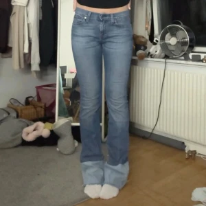 bootcut jeans med två tyg - Snygga jeans i klassisk blå denim med bootcut passform. Jeansen har en cool detalj med ljusare muddar längst ner och råa kanter. Perfekta för dig som vill ha en unik twist på dina jeans.