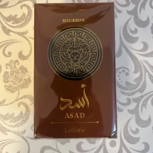 Lattafa Asad Bourbon Parfym - Asad Bourbon från Lattafa – en parfym med stilren design och ingredienser som limonene, citronellol, linalool och kanel. Perfekt för dig som vill sticka ut med något unikt. Tillverkad av Lattafa Perfumes Ind. L.L.C.