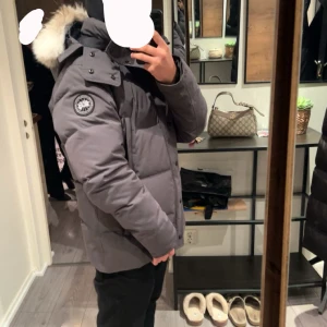 Canada goose Wyndham - Jätte fräsch Canada Goose Wyndham, storlek L men passar garanterat en M. Helt fräsch, fläckfri och rökfri. Kan gå med på en snabb affär. Pälsen är större en vanligt för att jag beställde den separat efter storlek.  