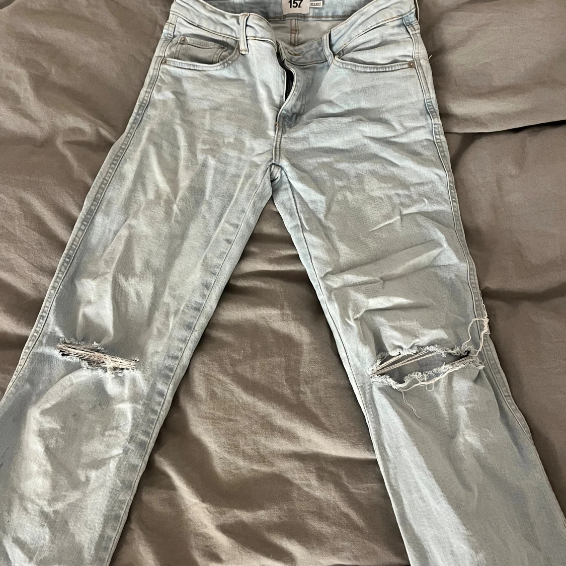 Ljusblå bootcut jeans med slitningar