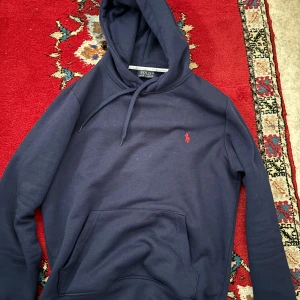 Marinblå hoodie från Polo Ralph Lauren - Säljer en marinblå hoodie från Polo Ralph Lauren i storlek M. Tröjan är i nyskick. Nypris ca 2000. Kan gå ner i pris vid snabb och smidig affär 💨 