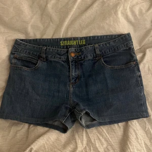 Blå jeansshorts Straight Leg xl-xxl - Säljer ett par klassiska blå jeansshorts från Straight Leg. Modellen har rak passform, fem fickor och knapp- samt dragkedja framtill. Snygga kontrastsömmar och midwaist. Perfekta för chill dagar och enkel att matcha med t-shirt eller hoodie.