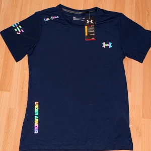 Blå Under Armour HeatGear t-shirt - Säljer en riktigt snygg under armour heat-gear Tshirt i mörkblå. Den är helt ny med prislapp kvar och påse medföljer. Med frågor eller funderingar? Tveka inte på att höra av dig!.