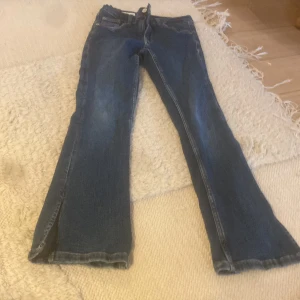 Blå bootcut jeans från Zara, stl 140 - Snygga blå jeans från Zara i bootcut-modell med slits nertill på benen. Klassisk femficksdesign och normal passform. Perfekta för dig som gillar en lite vidare siluett och coola detaljer. Tillverkade i jeansmaterial.