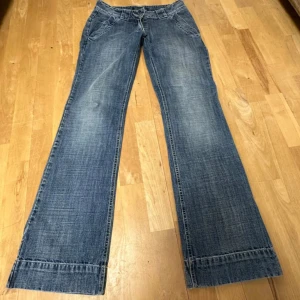 lågmidjade bootcut jeans - Lågmidjade bootcut jeans med snygg tvätt och fickor!! Innerbenslängd:85, midja:40. Jeansen är helt hela och har ingen fläck!