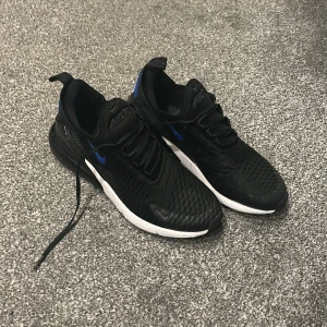 Nike Air Max 270 svart/blå  - Säljer ett par Nike Air Max 270 svarta med blå detaljer och vit sula. Skorna är köpta i Dannmark på Jd sports för 1750 kr. Skorna passar inte längre så jag växt ur dom. 
