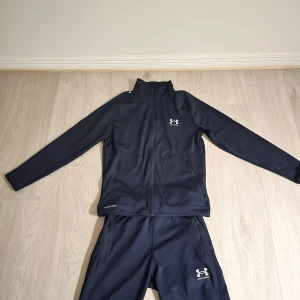 Under armour Tracksuit - Säljer nu en tracksuit ifrån Under Armour i väldigt fint skick. Väldigt skönt material och enkel att matcha med. Passa på och fynda🚀