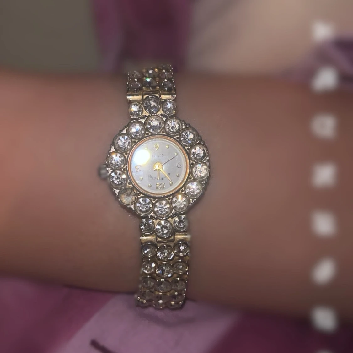 Glittrig guldfärgad klocka med stenar