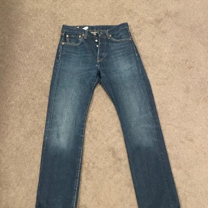 Levi's 501 jeans blå W29 L32 - Klassiska Levi's 501 jeans i blå denim med raka ben och knäppning fram. Snyggt slitna detaljer och kontrastsömmar. Modellen är midja och har fem fickor. Märkt med Levi's Premium på insidan. Är i väldigt bra skick