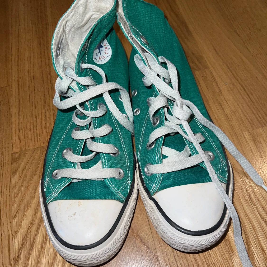 ett par grön Converse skor