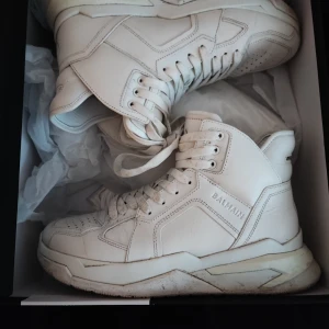 Bamain Bball High top sneakers - Vita Bball high top sneakers i kalv skinn från modehuset Balmain i väldigt bra skick i strl 42 EU. Bud kan accepteras.