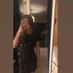 Klänning blommo slimfitt - En svart klänning med små blommor på, går längst kroppen och skickas me bra skick. 