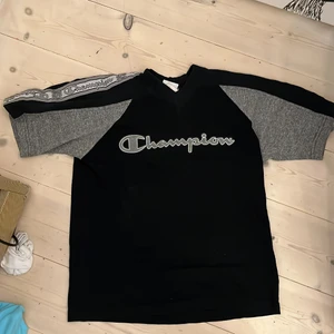 Champion T-shirt  - Champion tröja som är så jävla snygg men används inte tillräckligt. köpte secondhand så jag vet inte vad original skicket är men inga fel jag ser så antar 10/10, har ränder på armarna! Möts upp i sthlm och tar bara swish ( det är strumpor på golvet )
