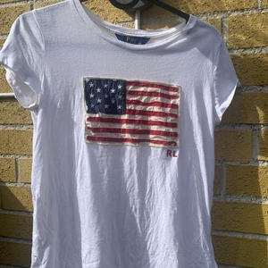 Polo Ralph lauren usa flagga - Intressekoll! På en t shirt med det trendiga trycket med en usa flagga på. Har i ljusgrå också. Skriv om ni har frågor :)