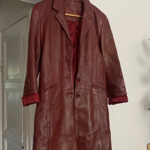 Vintage kappa i läder  - Vintage vinröd kappa i läder, jättebra skick, strl S,34-36 
