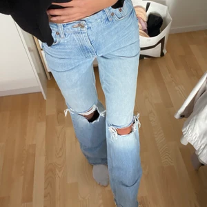 Zara blå ripped jeans stl 34 - Högmidjade jeans med hål vid knäna. Supersnygg passform & längre så dom lägger sig snyggt på skorna. Säljer då de är aningen för tajta för mig som vanligtvis bär stl 36🥰