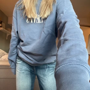 Blå sweatshirt - Snygg blå sweatshirt med vitt levismärke, i jättebra skick!
