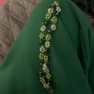 Fint halsband med flera olika färgersblommor! Guld och olika nyanser av grönt. Handmade.