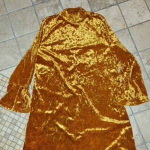 Fest / aftonklänning  - Festlig klänning i krossat sammet. Från Monki, st M. Rak i figuren med 3/4 ärm. Lite öppen i ryggen med två knappar för att stänga krage i halsen. På mig ca 152cm slutar klänningen lite under knälängd. Använd en gång och tvättad.