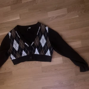 En tröja. - En stikad tröja med tre knappar. Den är tvättad.