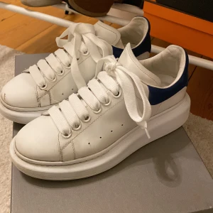 Alexander McQueen sneakers - Alexander McQueen sneakers med blå häl i mocka, strl 37 men lite större i storlek. Använda men ändå fint skick. Box medföljer. 