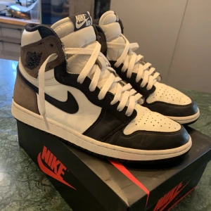 Jordan 1 mocha high - Jag säljer mina Jordan 1 mocha high, storlek 43. Skorna är i väldigt bra skick, sulan är dock lite sliten men inget man ser när man har skon på. Svarta och vita snören ingår och självklart sko lådan också. Äkthets bevis finns. Köparen står för frakt.