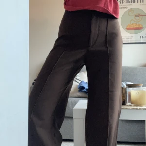 Kostymbyxor  - Bruna kostymbyxor i en rak modell. Sparsamt använda Jag är 156cm och byxorna går ner till golvet