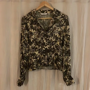 Blommig blus från & Other stories - Blommig, silkeslik blus från & Other Stories. Figursydd.