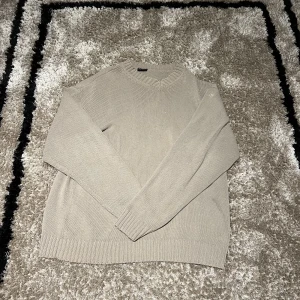 Stickad tröja  - Stickad tröja från sand. Bra skick förutom ett litet hål på ena armen och en pytteliten fläck. Passar L