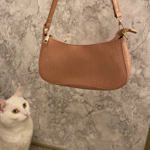 Rosa axelväska - Nu säljer jag även denna rosa axelväska. Jag har fått den i födelsedagspresent för att tag sen så jag vet inte vad den kostade men jag säljer den för 70kr. Jag har knappt använt den så den är i väldigt bra skick, som ny, ingen som helst skada❤️