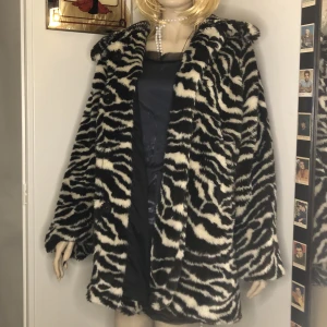 Zebramönstrad jacka i fuskpäls - Fluffig och mysig jacka i bra skick! Går att stänga med knappar men en knapp saknas. 