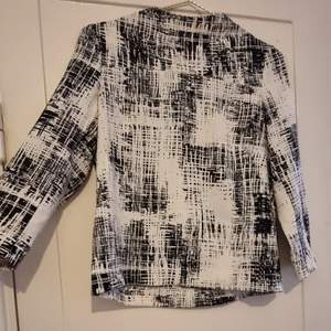 Snygg svartvit mönstrad tröja med lite krage 