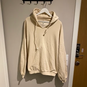 Oversized, beige tjocktröja med luva  - Snygg och skön tjocktröja, oversized, från Nelly.com. Skickas eller hämtas hos mig på Fridhemsplan. 