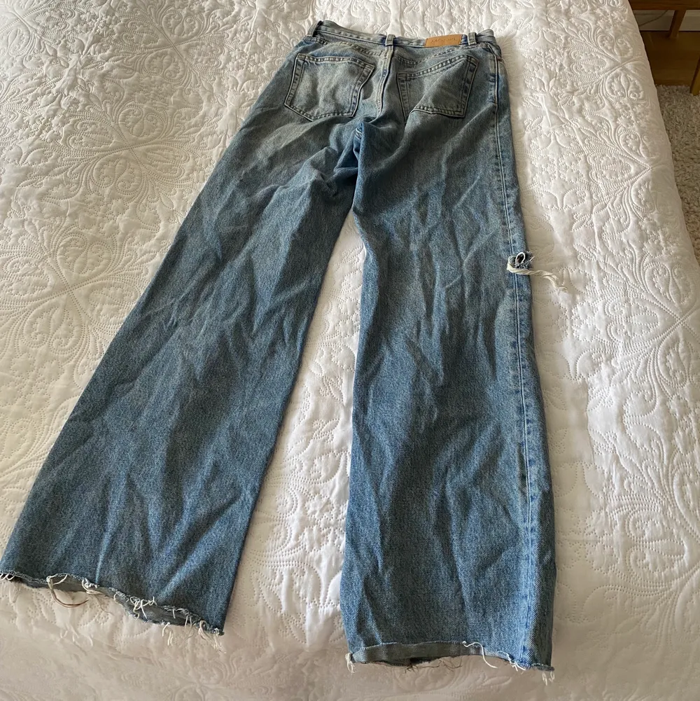 Fina utsvängda jeans från MONKI med slitning på sidan av benet. Väl använda och därmed har dom en liten fläck längst ner på benet. Jeans & Byxor.