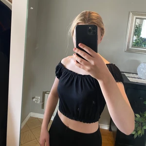 Svart topp strl S - Svart croppad topp från HM med stretchigt resorband runt magen som formar kroppen. Kan antingen ha den off shoulder eller över axlarna. 🖤🖤