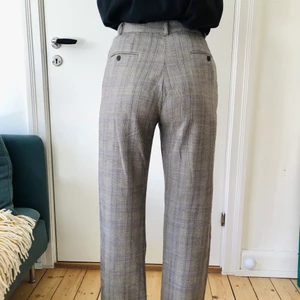 Rutiga grå kostymbyxor strl 36 - Riktigt snygga kostymbyxor i vintage stil! Snygg passform med hög midja och lite blått i det grå rutiga mönstret. Strl 36 ungefär.