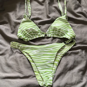 Bikini - Grön  - En grön zebra bikini med sarong, inte använd mycket (tvättar självklart allt innan de skickas) - Storlek M