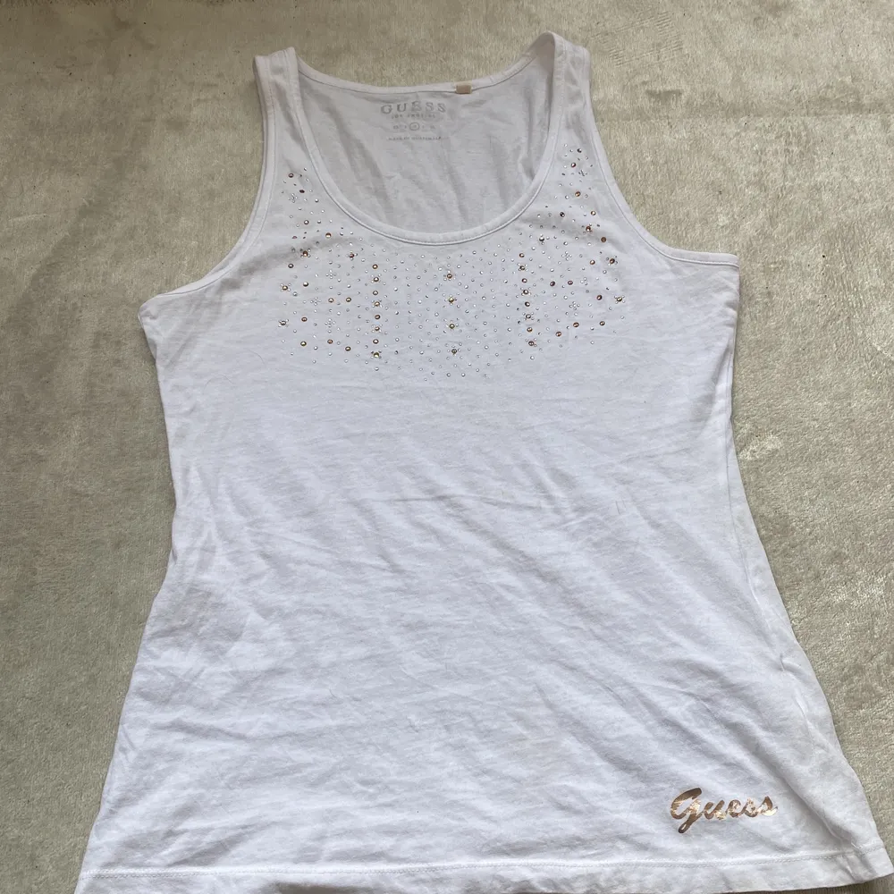 Guess linnne vitt med Cristaljer vid bröstkorgen är u ringad i storlek S-M . T-shirts.