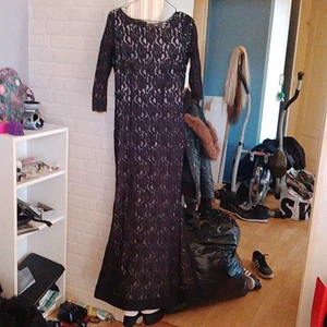 Aftonklänning  - Aftonklänning med extra tygskena i nederkant för extra fint fall. Svart spets över beige tyg stretchigt material 