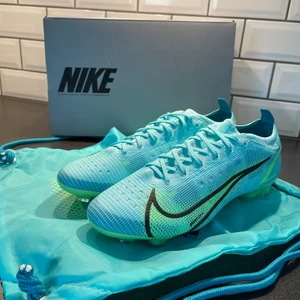 Nike Mercurial Elite - Säljer mina Nike Mercurial Vapor 14 Elite - Turkos/Grön FG, skorna är helt nya och inte ens testade! Köparen står för frakten, Pris kan som alltid diskuteras! Kvitto, orginaltrogen och även skopåsen medföljer! Pris diskuteras!
