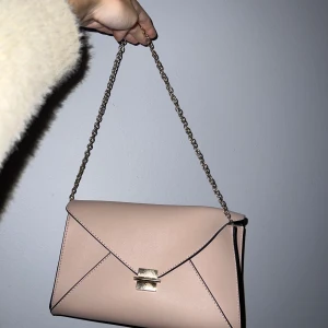 Ljusrosa väska  - Säljer denna oanvända ljusrosa väska för 100kr. Den har guldiga detaljer.  Den har inget speciellt märke, Det går inte att göra kedjan länge och om ni har frågor om mått så är det bara att fråga Kan mötas i Malmö men också frakta! Frakt står man själv för